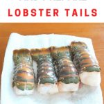 Four raw lobster tails draining on a sheet of paper towel.