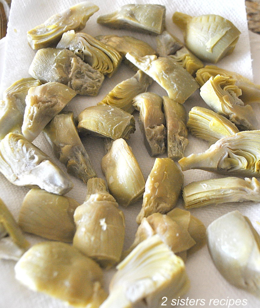 A photo of frozen artichoke hearts on a paper towel. 2sistersrecipes.com