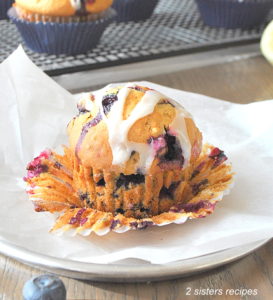 a photo of a muffin with paper liner pulled back. by 2sistersrecipes.com
