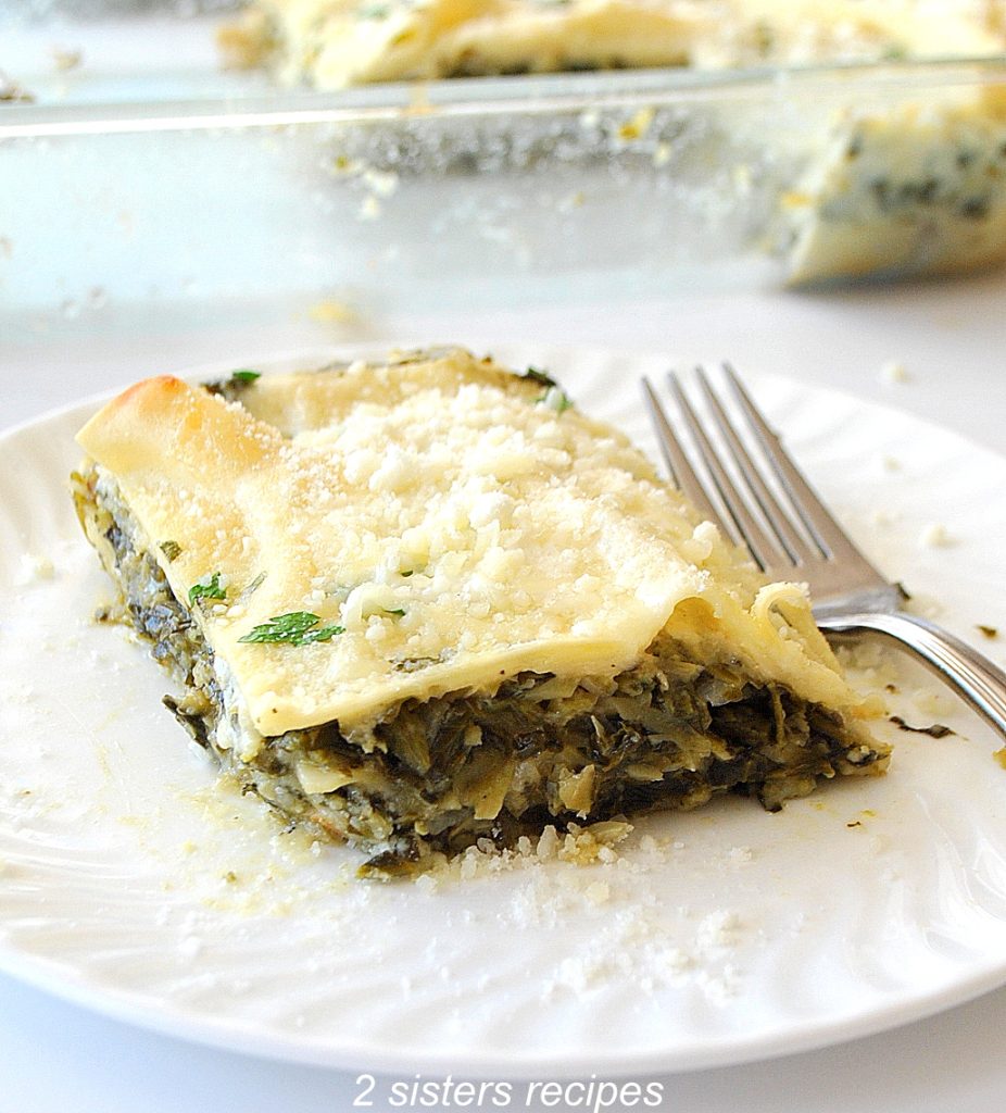 Spinach and Artichoke Lasagna served on a white plate with a fork. 