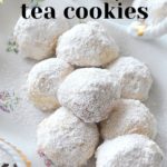 A white ceramic dish filled with bite-sized cookies covered with white powdered sugar.