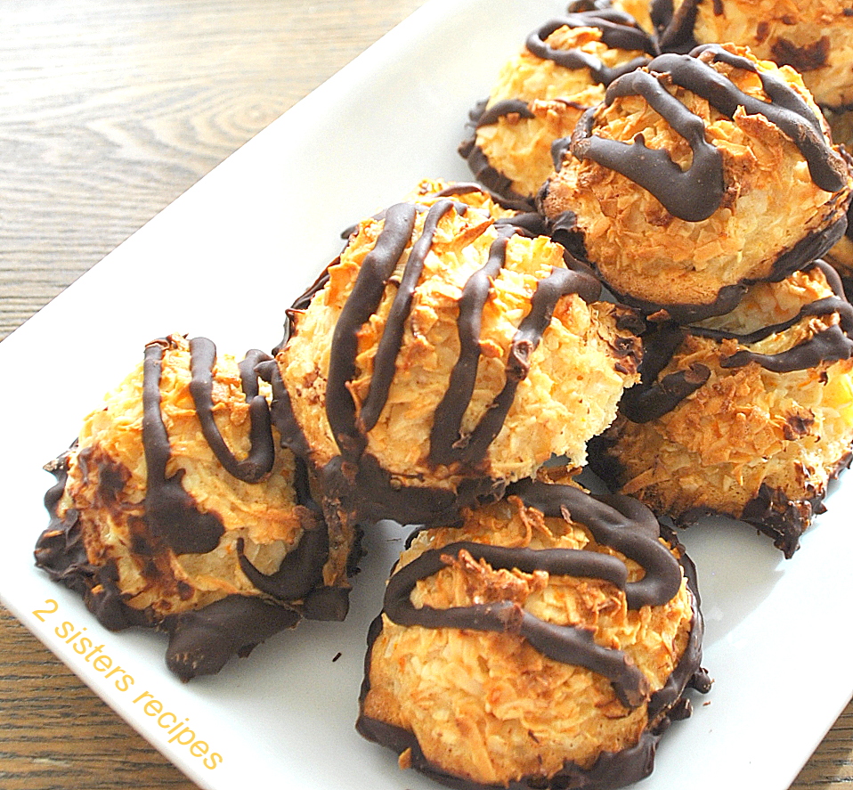 A white platter filled with macaroon cookies with chocolate drizzled on top.
