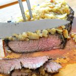 Carvng steak on a cutting board. by 2sistersrecipes.com