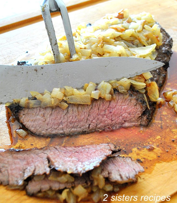 Carvng steak on a cutting board. by 2sistersrecipes.com