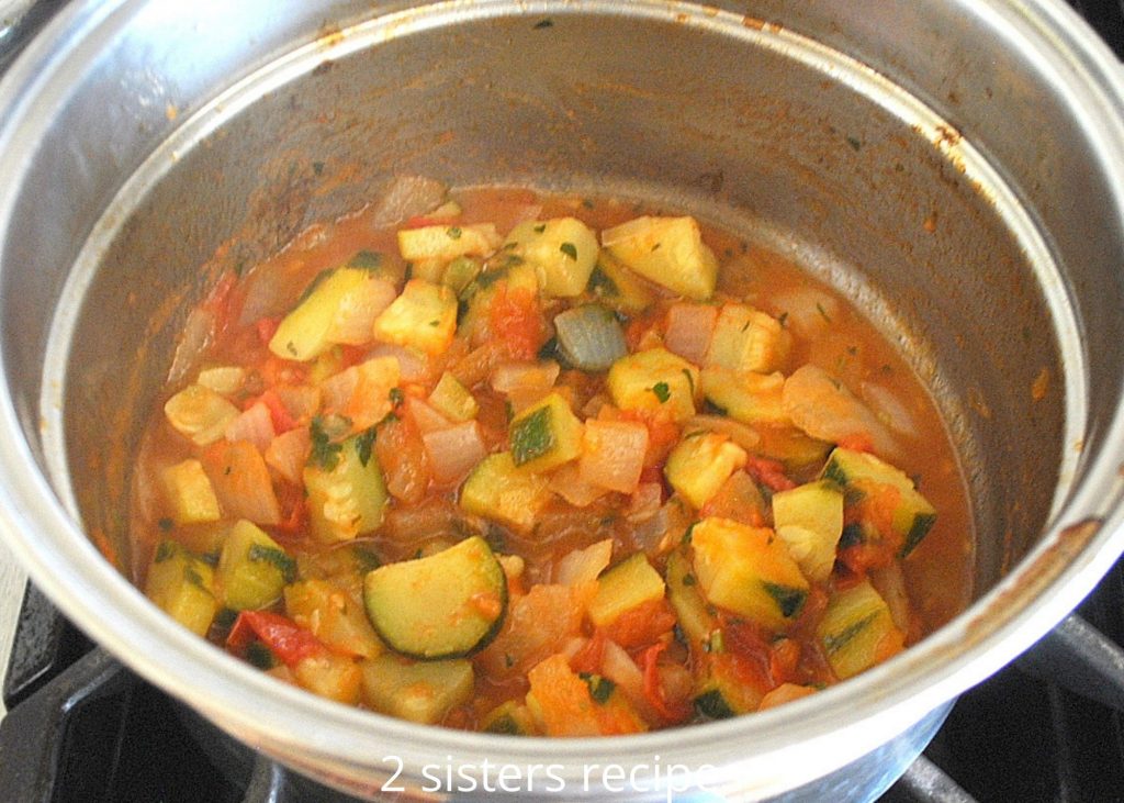 The zucchini mixture cooked in a saucepot. by 2sistersrecipes.com