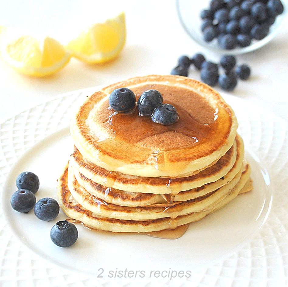 A stack of small pancakes with fresh blueberries on top. 