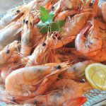 A platter filled with boiled shrimp.