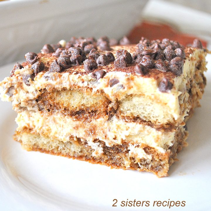 A square piece of Tiramisu dessert, served on a white plate.