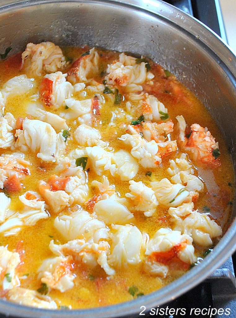 A skillet with lobster tails sauce.