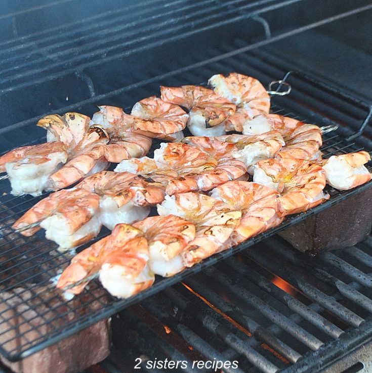 grilling shrimp kabobs n an outside grill. by 2sistersrecipes.com