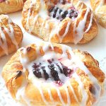 A few baked Danish pastries served on a white plate.