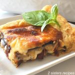 Italian Savory Eggplant Tart is served on a white plate with fresh basil on top.