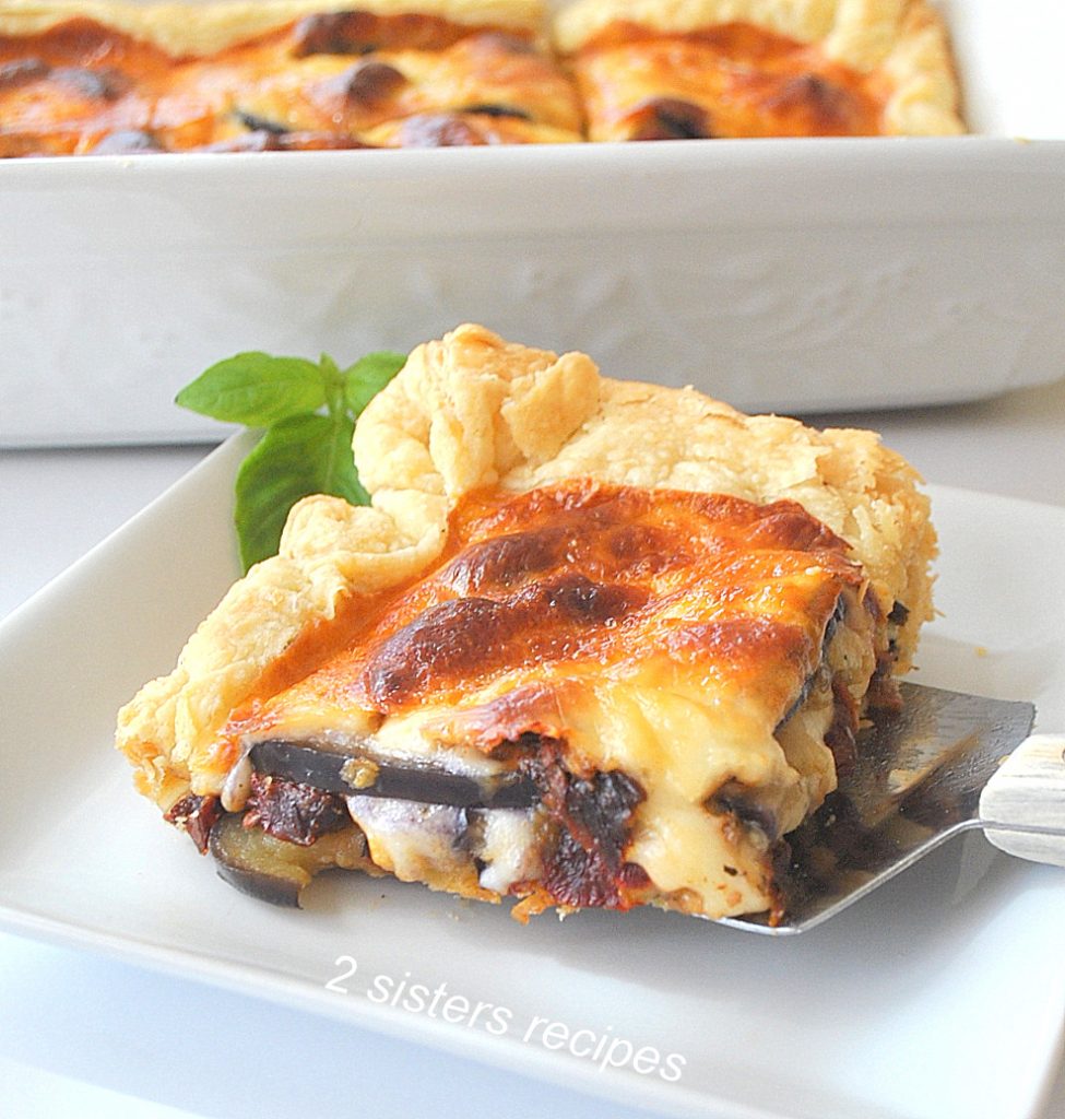 An slice of an Eggplant Tart served on a white plate. by 2sistersrecipes.com
