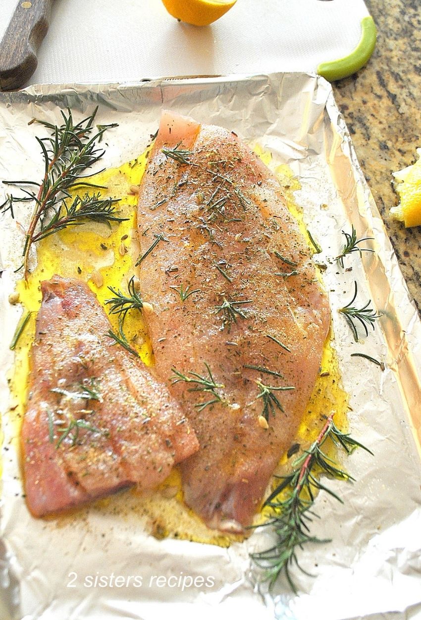 Fillet of red snapper prepped on a baking pan. by 2sistersrecipes.com