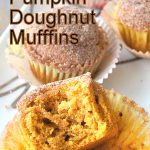 Pumpkin muffins served on a white and silver platter with a half of one muffin displayed.