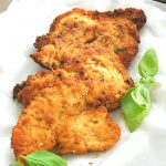 Fried chicken cutlets served on a white platter.