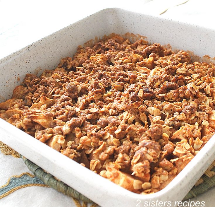 A white baking pan baked with Apple Crisp. by 2sistersrecipes.com
