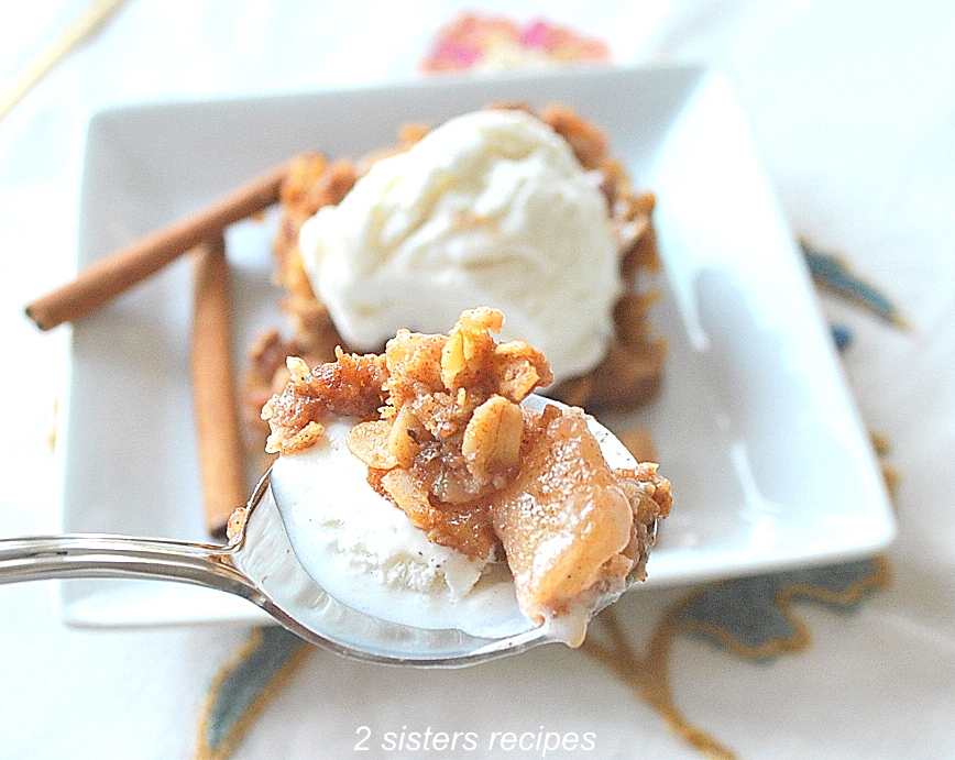 A spoonful of ice cream with some apple crisp. by 2sistersrecipes.com