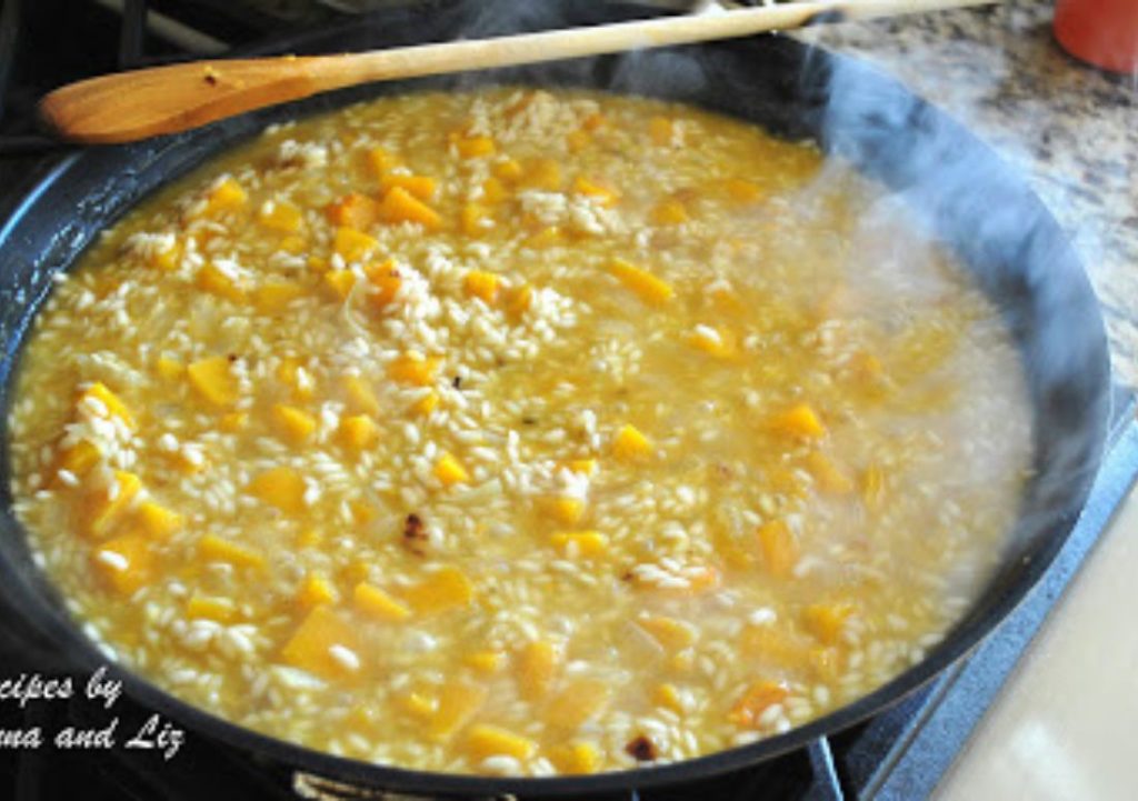 In a large skillet, butternut squash is simmering with rice. by 2sistersrecipes.com