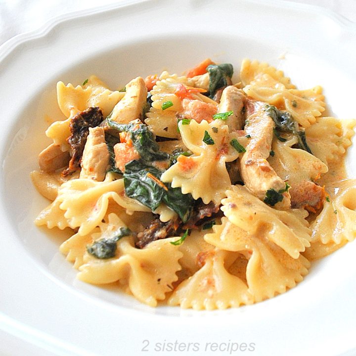 A dish of farfalle pasta and pieces of chicken in a bowl.