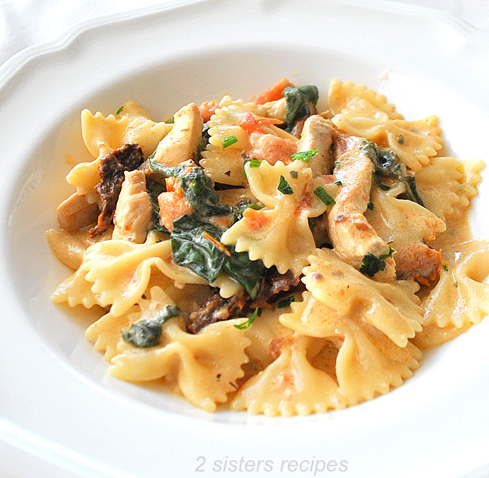 A dish of farfalle pasta and pieces of chicken in a bowl.