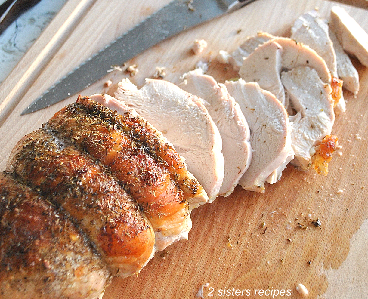 Top 12 Favorite Recipes for 2022 is A turkey breast sliced on a wood cutting board. by 2sistersrecipes.com