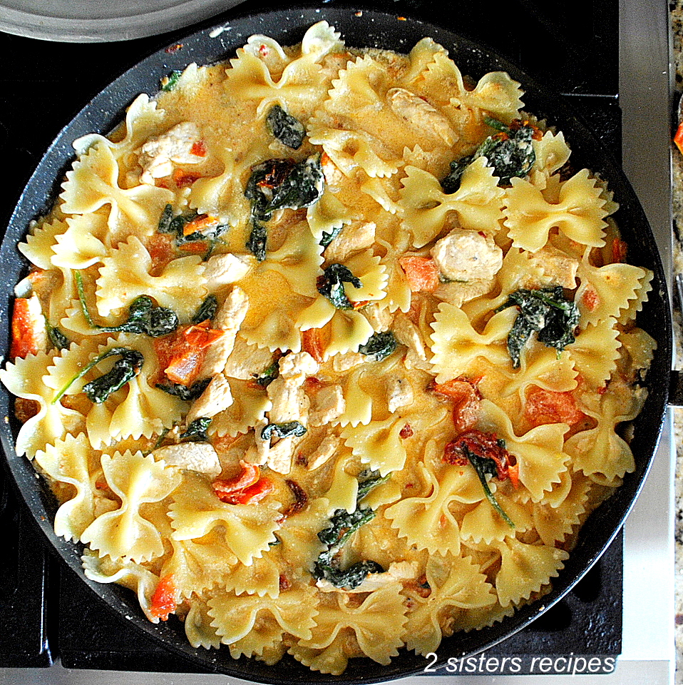One-pot skillet filled with bow-tie pasta, pieces of chicken in a light cream sauce.