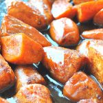 A sheet pan filled with sweet potatoes roasted with a cinnamon and honey glaze.