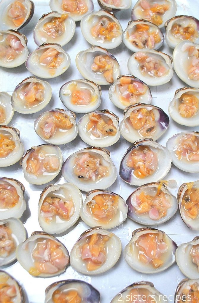 raw clams in a single layer in a baking dish. by 2sistersrecipes.com