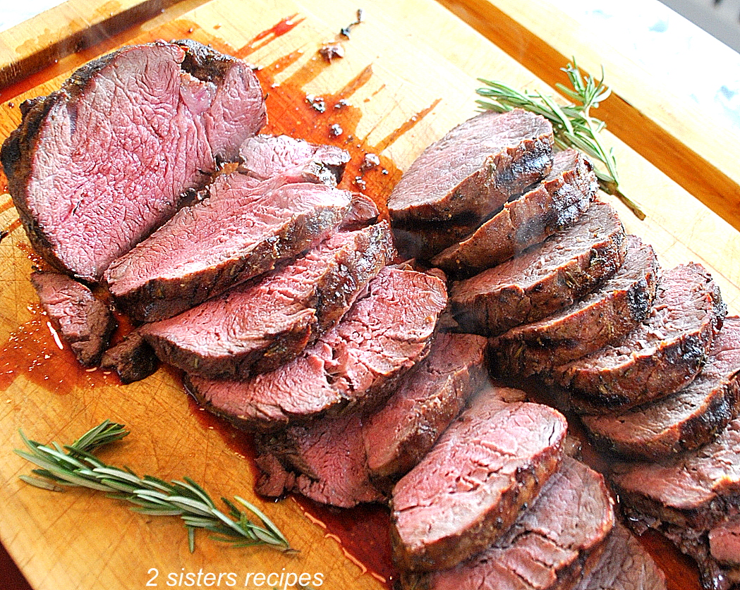 Beef Tenderloin is sliced on a cutting board.