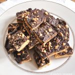 A white round plate filled with toffee bars.