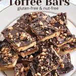 A White dish with a large serving of toffee bars piled on top of one another.