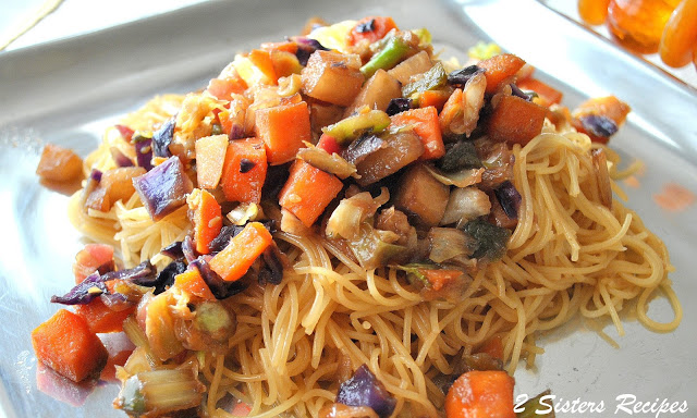 Capellini pasta with cooked veggies on top on a silver platter. by 2sistersrecipes.com