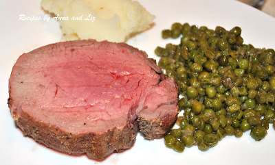 A slice of steak with peas and mashed potatoes on a white plate. by 2sistersrecipes.com
