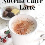 Nutella Caffe Latte served in a white mug with some chocolates on the side.