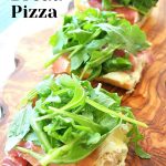 A pieces of French Bread Pizza served on a wood board.