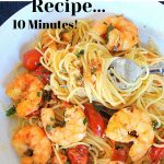 A forkful of spaghetti in a plate filled with cooked shrimp and cherry tomatoes and olives.