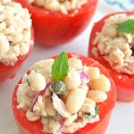 Little tomatoes hollowed out and stuffed with white bean salad topped with a mint and capers.