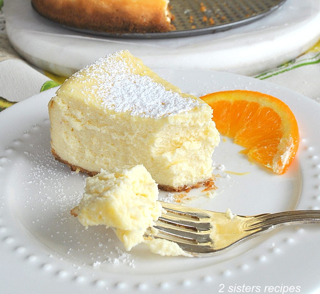 a slice of cheesecake on a white plate. by 2sistersrecipes.com