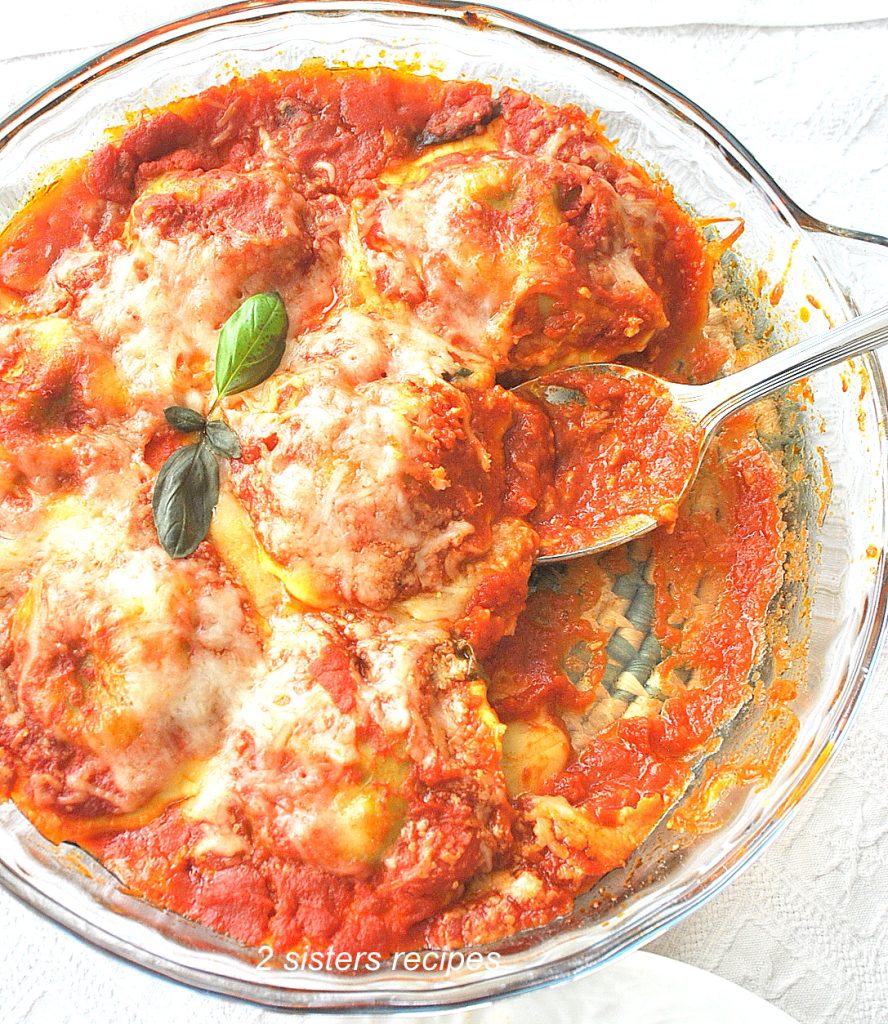 A spoonful of ravioli covered with tomato sauce and cheese.