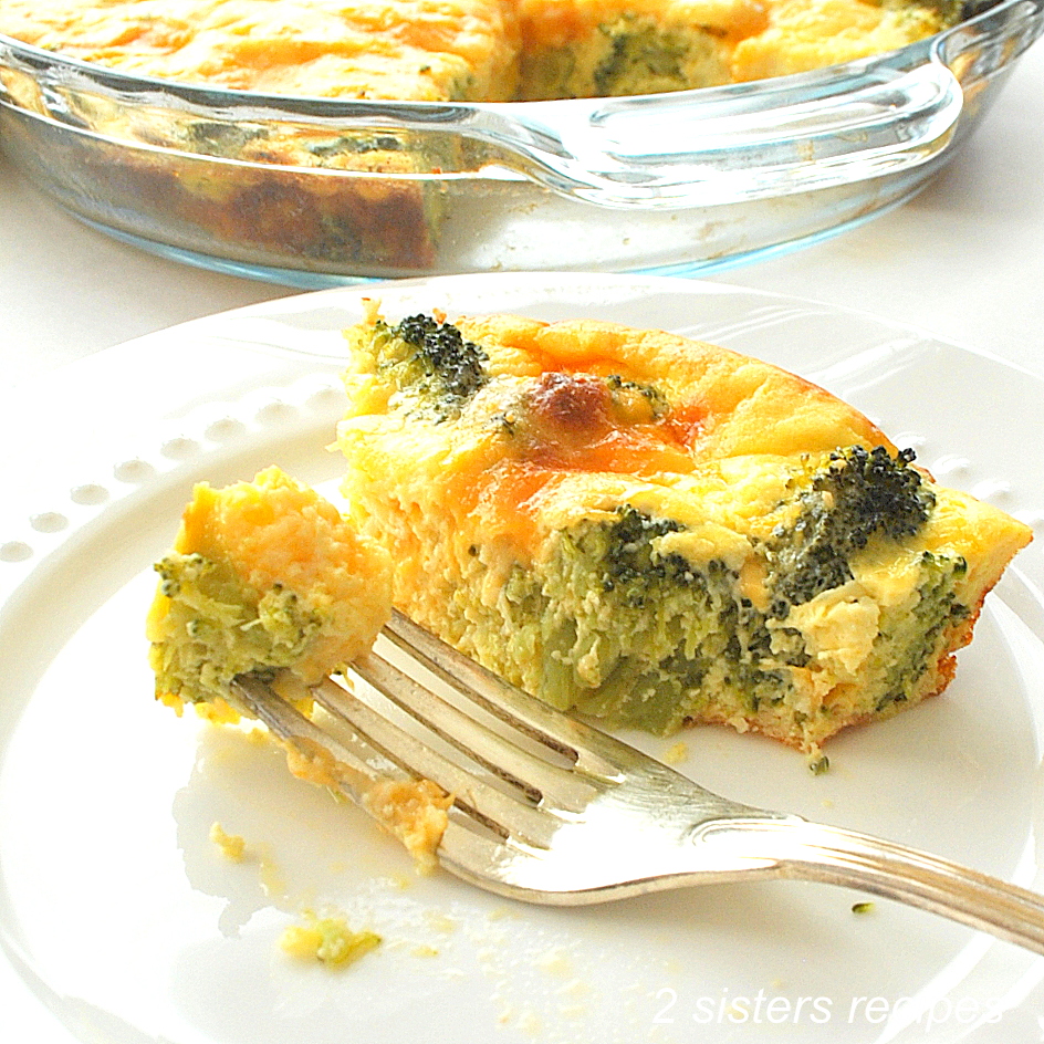 A slice and forkful of quiche on a white plate. by 2sistersrecipes.com