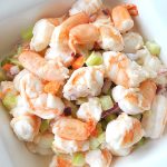 A white bowl filled with shrimp salad.