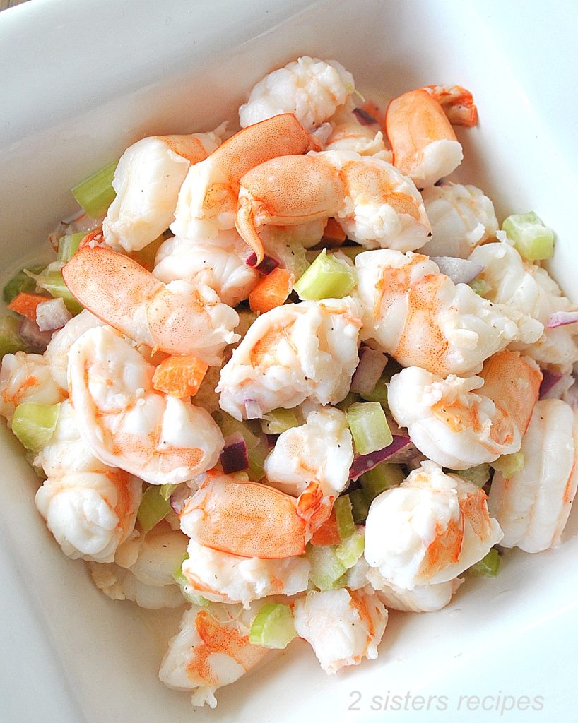 A white bowl filled with shrimp salad.