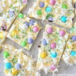 White chocolate squares topped with light colored M&M candies and shredded coconut.