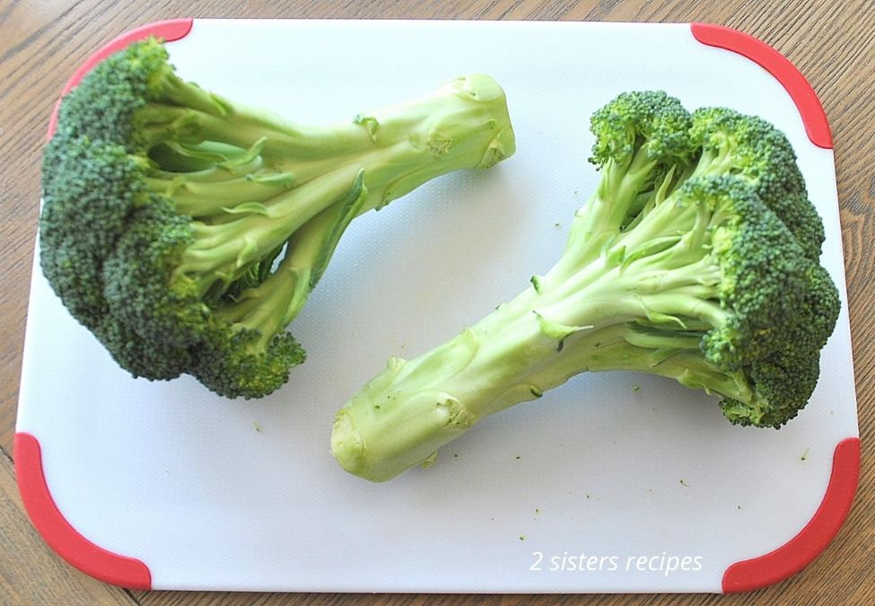 A photo of fresh broccoli on a white cutting board. by 2sistersrecipes.com