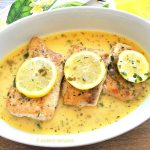 Pan-Seared Mahi Mahi served in a white oval platter with lemon slices on top.