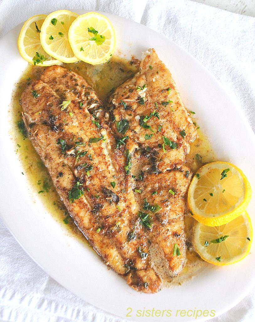 Cooked filet of sole in a lemon sauce on the serving platter, with lemon slices on the side.
