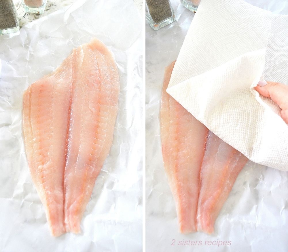 One raw filet of fish on wax paper, pat drying with paper towel. 