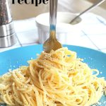 A blue plate with a fork twirling spaghetti with cheese.