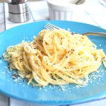 A blue plate with a serving of spaghetti and a fork.